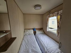 2 camas en una habitación pequeña con ventana en Lido Beach RUTH NEW en Prestatyn