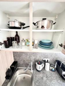a kitchen shelf with pots and pans and a sink at Franziskaner Suites #6 in Graz