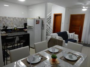 una cucina e un soggiorno con tavolo e frigorifero di Casa sobrado 7 a Guarujá