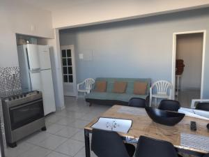 a kitchen and living room with a couch and a table at Suites e Kitnets praia Iriri in Anchieta