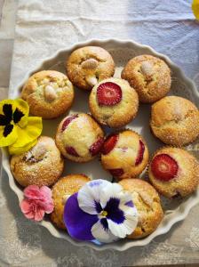 um prato de muffins com flores numa mesa em Fra Bosco e Cielo B&B em Mercato Saraceno