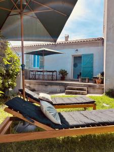 2 lits assis sur l'herbe sous un parasol dans l'établissement Villa Lutèce - Vue mer, à Bastia