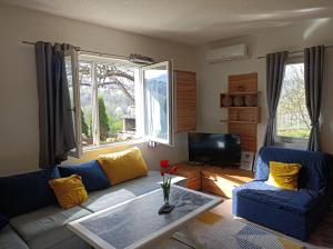 a living room with two blue couches and a tv at Kavkaz Apartment in Sarajevo
