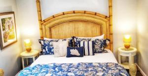 a bedroom with a large bed with blue and white pillows at The Whalewalk Inn & Spa in Eastham