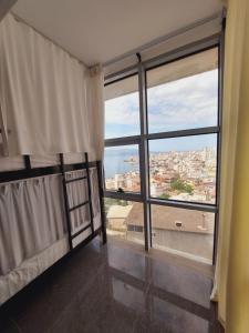a room with a large window with a view at Saranda Boutique Hostel in Sarandë