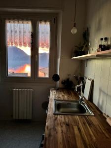 a kitchen with a wooden counter top and a sink at Le allodole in Bellano