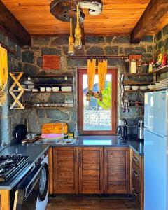 uma cozinha com um lavatório, um fogão e uma janela em AXÂRA VİLLA SUİT em Pazar