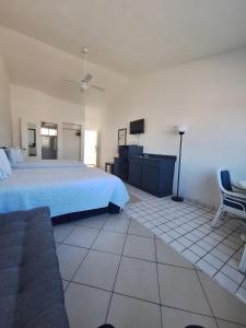 a bedroom with a bed and a tv and a couch at Playa Inn Rocky Point in Puerto Peñasco