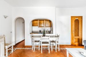 una cucina e una sala da pranzo con tavolo e sedie di PORTO CERVO-CALA DEL FARO [Parking-Sea-Garden] a Porto Cervo