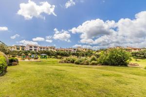 un parco di fronte a un grande edificio di PORTO CERVO-CALA DEL FARO [Parking-Sea-Garden] a Porto Cervo