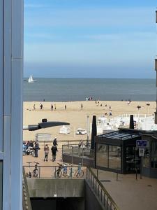 una spiaggia con persone sulla sabbia e sull'oceano di Logies Windsor One Room a Ostenda