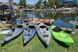 three kayaks sitting on the grass near a body of water at *NEW* POOL screened-in, Waterfront, 4 Kayaks, Pet in Hernando Beach