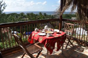 a table with a red table cloth on a balcony at Seven Heaven do Indico in Inhambane