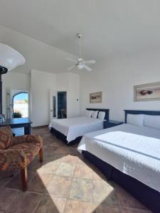 a bedroom with two beds and a couch and a fan at Playa Inn Rocky Point in Puerto Peñasco