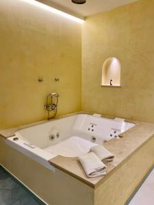 a large white bath tub in a bathroom at Alcoba del Rey de Sevilla in Seville