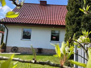 魯恰內尼達的住宿－Dom całoroczny Wczasy jak Marzenie，白色的房子,有红色的屋顶和两个窗户