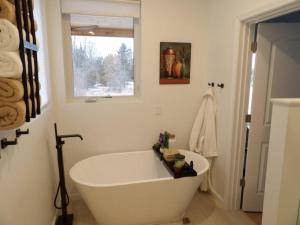 a white bath tub in a bathroom with a window at La joie de vivre in South Haven +33 photos