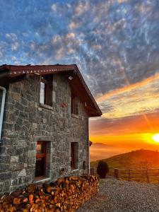 a stone building with a sunset in the background at AXÂRA VİLLA SUİT in Pazar