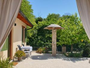 un patio con un tavolo e un ombrellone di “House Botić” a Durakovići