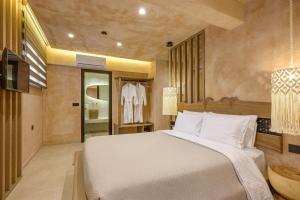 a bedroom with a large white bed and a bathroom at Salud Ierissos in Ierissos