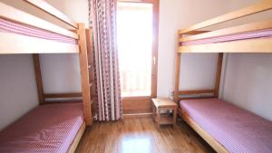Dos literas en una habitación con ventana. en Résidence Parc Aux Etoiles - CH13PAE - CHALET DUPLEX 2 CHAMBRES, BORD DE PISTE MAE-2264, en Narreyroux