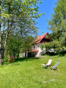 uma cadeira e um banco em frente a uma casa em Przystanek Zawadka em Zawadka