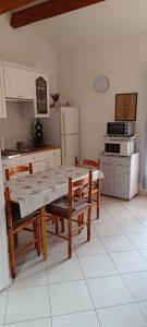 uma cozinha com uma mesa e cadeiras e um frigorífico em Maison provençale 5 personnes Gorges du Verdon em Saint-Martin-de-Brômes