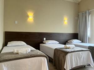 um quarto com duas camas com toalhas em Pousada Recanto Praiano em Angra dos Reis