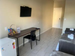 Cette chambre comprend un bureau, un lit et une télévision. dans l'établissement Pousada Recanto Praiano, à Angra dos Reis