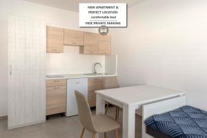 Una cocina con una mesa y sillas y un fregadero. en RM Roma Studio, en Celje
