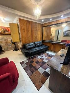 - un salon avec un canapé noir et une table dans l'établissement Apartamento completo no Centro histórico, à Ouro Preto