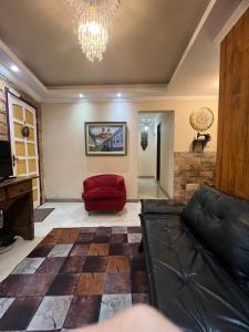 - un salon avec un canapé et un lustre dans l'établissement Apartamento completo no Centro histórico, à Ouro Preto