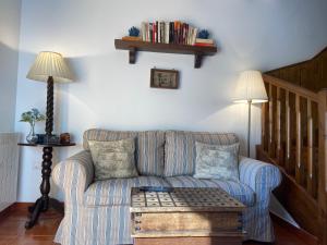 un soggiorno con divano e tavolo di PRECIOSO CHALET JUNTO A POTES CON PISCINA-4 Hab,3 Baños a Ojedo
