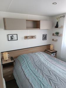ヴァルラ・プラージュにあるMobile Homes Sous le Soleilのベッドルーム1室(ベッド1台、エンドテーブル2台付)
