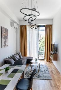 een woonkamer met een bank en een tafel bij Home Art Apartments in Skopje