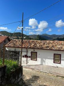 une maison blanche avec un toit en carrelage dans l'établissement Apartamento completo no Centro histórico, à Ouro Preto