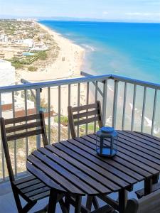 einen Holztisch auf einem Balkon mit Blick auf den Strand in der Unterkunft Amazing Seaviews in Faro de Cullera in Faro de Cullera