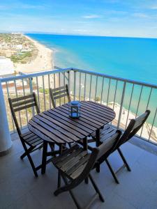 - une table et des chaises en bois sur un balcon donnant sur la plage dans l'établissement Amazing Seaviews in Faro de Cullera, à Faro de Cullera