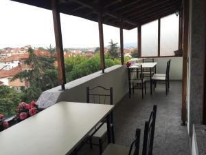a restaurant with tables and chairs on a balcony at Bora Apartment in Sandanski