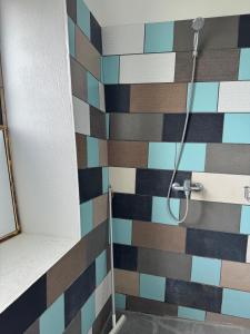 y baño con ducha y azulejos de colores. en Sunset Bungalow en Orissaare