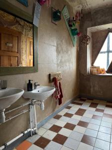baño con 2 lavabos y ventana en Sunset Bungalow, en Orissaare