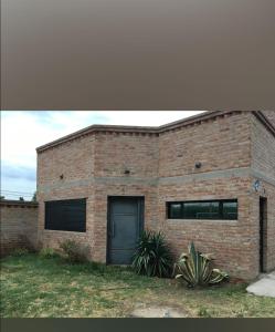 a brick building with a door and a yard at Josefina casa in Punta Alta
