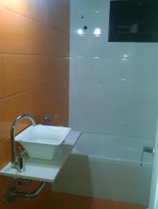 a bathroom with a white sink and a bath tub at Josefina casa in Punta Alta