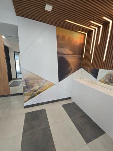 a room with a wall with paintings on it at Apartament Park Trzy Stawy in Katowice