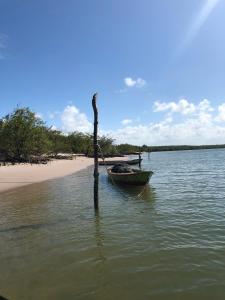 una barca seduta in acqua accanto a una spiaggia di Paraíso na Barra a Rio Tinto