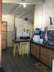 una cucina con 2 sgabelli gialli e un bancone di Paraíso na Barra a Rio Tinto