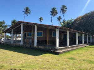a small house with palm trees in the background at Paraíso na Barra de Mamanguape Beira do Rio in Rio Tinto
