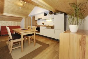 eine Küche und ein Esszimmer mit einem Tisch und Stühlen in der Unterkunft Aktiv-Ferienwohnungen Montafon in Sankt Gallenkirch