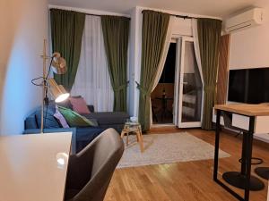 - un salon avec un canapé bleu et une table dans l'établissement Marina City key Luxury Studio, à Podgorica