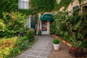 une entrée à un bâtiment avec un panneau sur celui-ci dans l'établissement Le Relais Cicero, à La Flèche